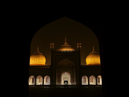 A mosque with a golden dome at night