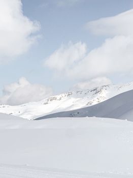 Peaceful winter landscape with snow-covered hills and clouds in Isparta, Türkiye.