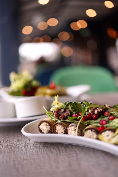 Free Elegant plated appetizers with arugula, walnuts, and pomegranate seeds, perfect for festive dining. Stock Photo