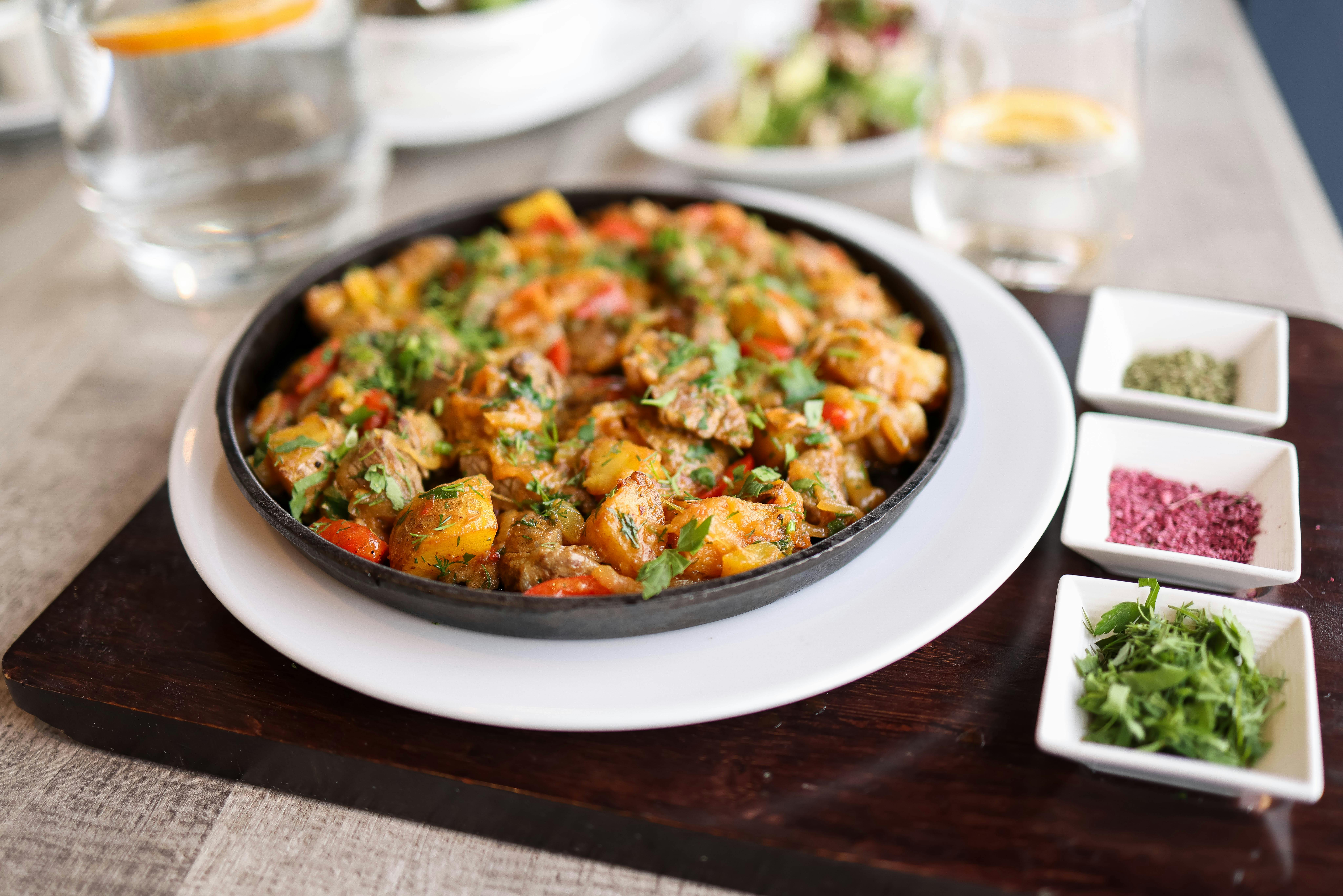 A vibrant and flavorful dish of mixed vegetables and meat, garnished with fresh herbs.