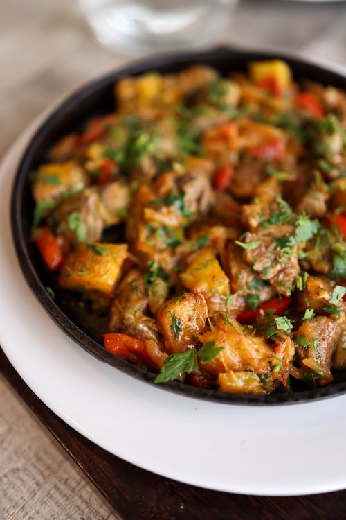 Free Close-up of a vibrant bell pepper and meat skillet, garnished with fresh herbs. Stock Photo