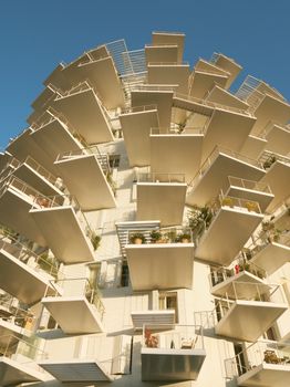 Stunning modern architecture featuring unique cantilevered balconies against a clear blue sky.