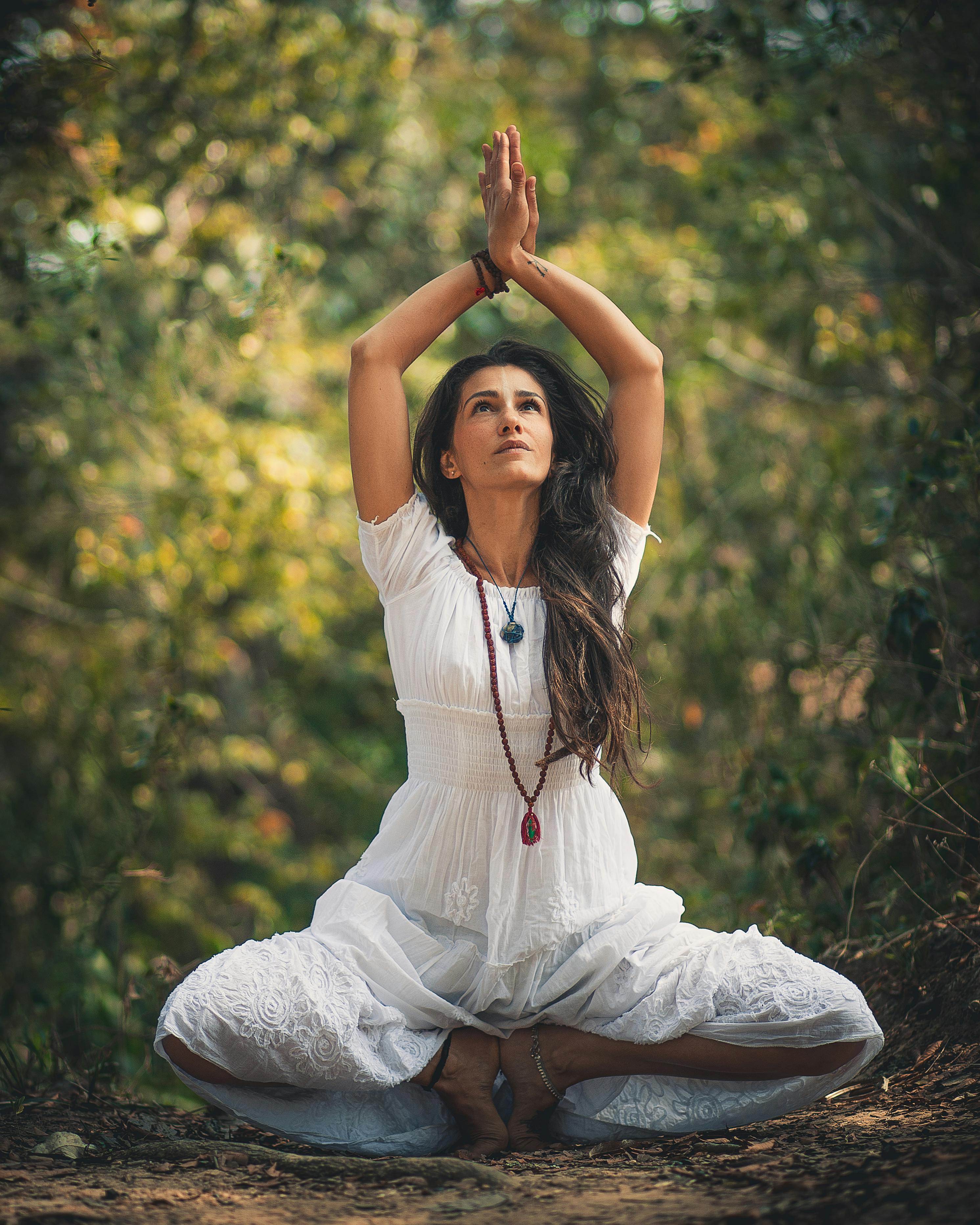 woman squatting on ground while raising both hands