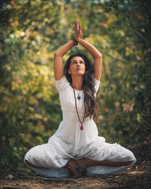 Free Woman Squatting on Ground While Raising Both Hands Stock Photo