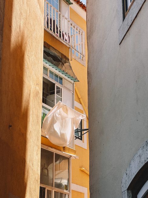 Vibrant urban residential building with drying laundry between tight alley walls.