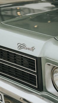 Close-up of a vintage Chevrolet car showcasing its chrome grill and hood emblem.