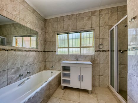 Explore this elegantly designed bathroom featuring a bathtub, vanity, and shower, perfect for modern living.
