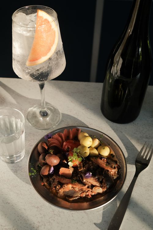 Free Gourmet platter with colorful vegetables accompanied by a refreshing gin and tonic in a dining setting. Stock Photo