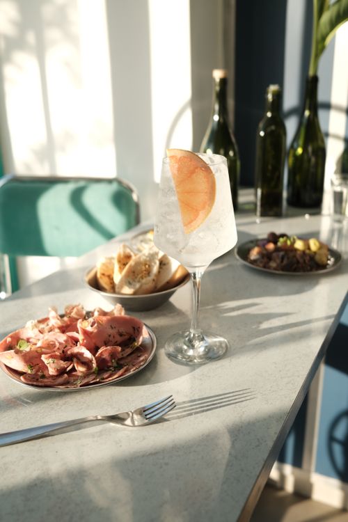Free A refreshing grapefruit cocktail paired with delicious appetizers on a sunlit table, creating a vibrant dining atmosphere. Stock Photo