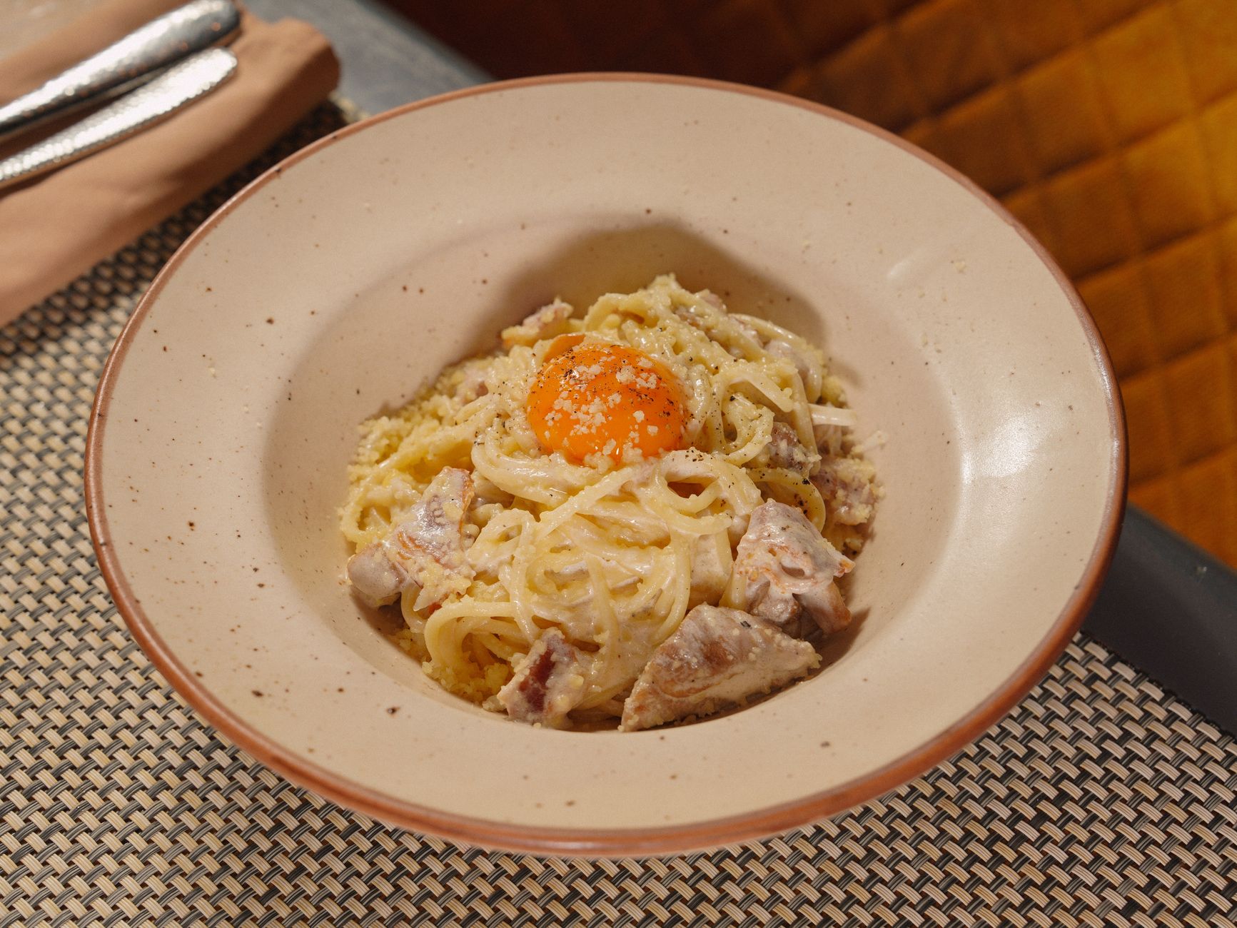Carbonara topped with a golden egg yolk