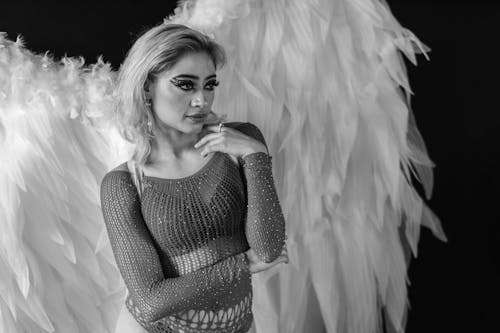 A woman with angel wings posing for a black and white photo