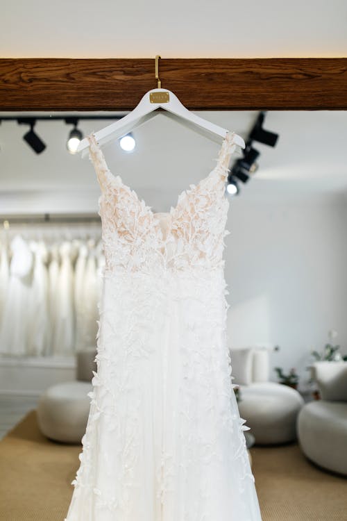 A wedding dress hanging on a rack in a store