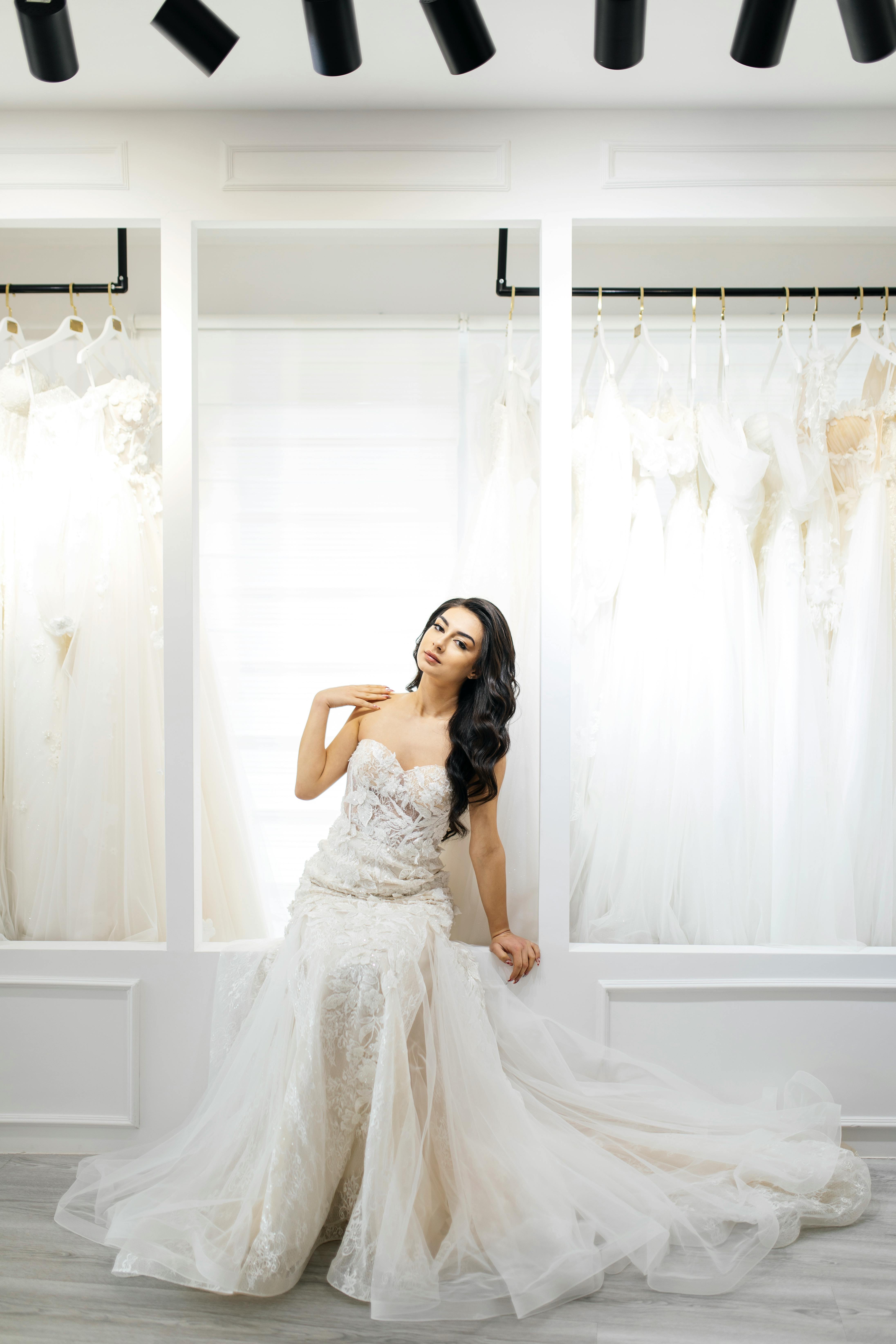 Radiant bride posing in a luxurious bridal store, showcasing an elegant wedding gown.