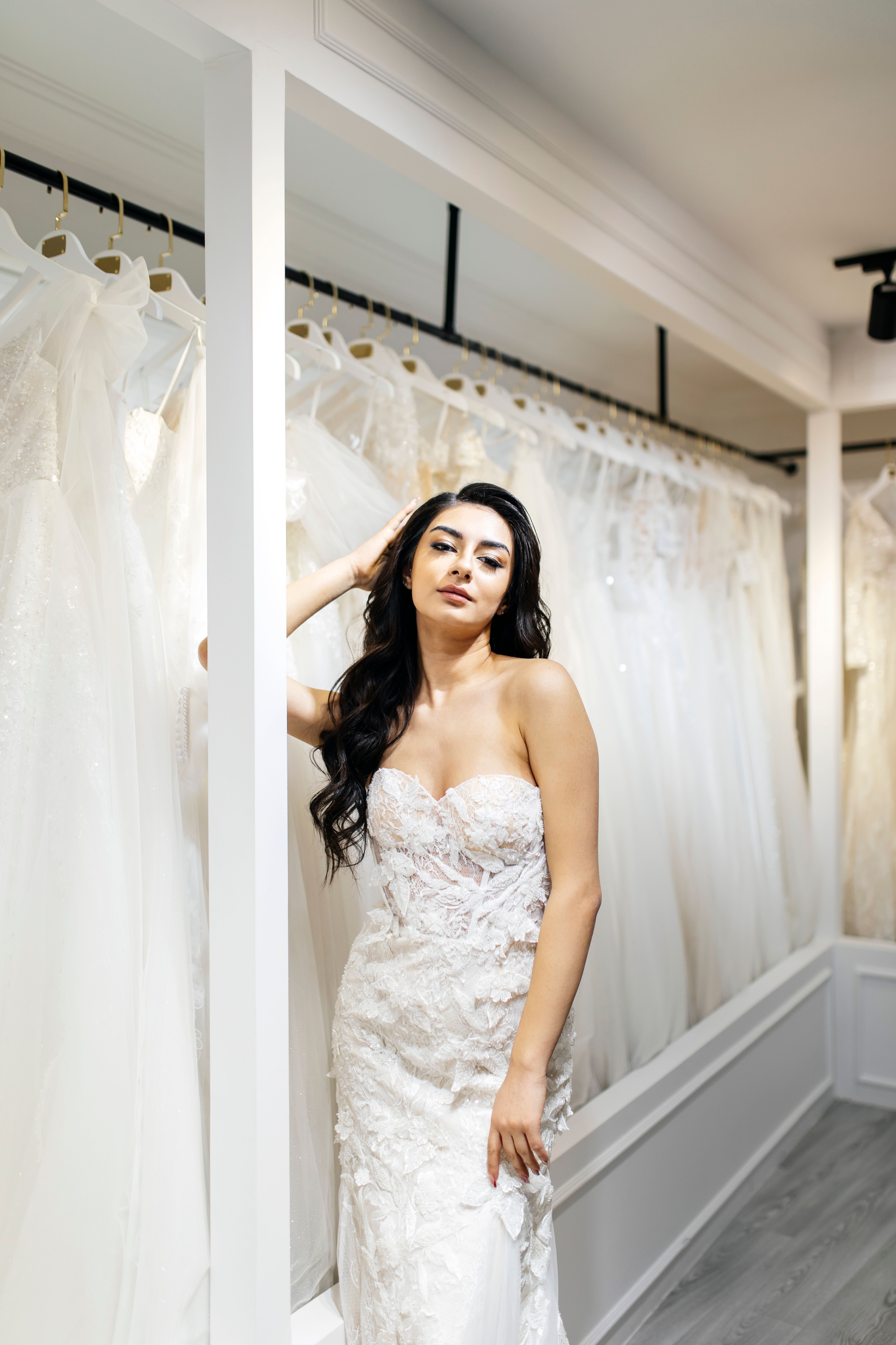 Beautiful bride posing in a wedding dress boutique, showcasing elegance and style.