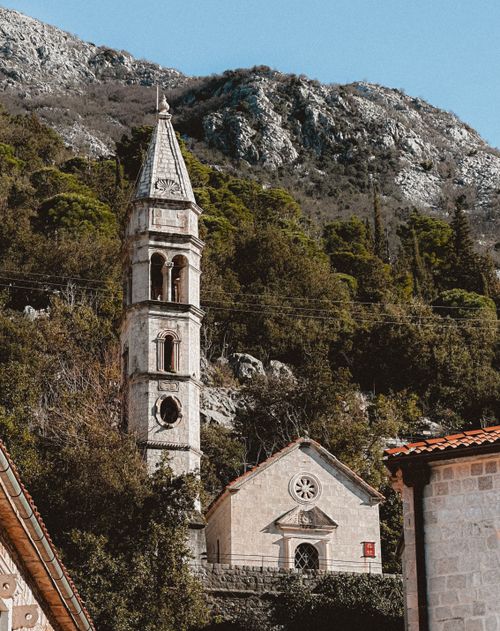 Free Charming church tower nestled in the hills of Perast, Montenegro. Stock Photo