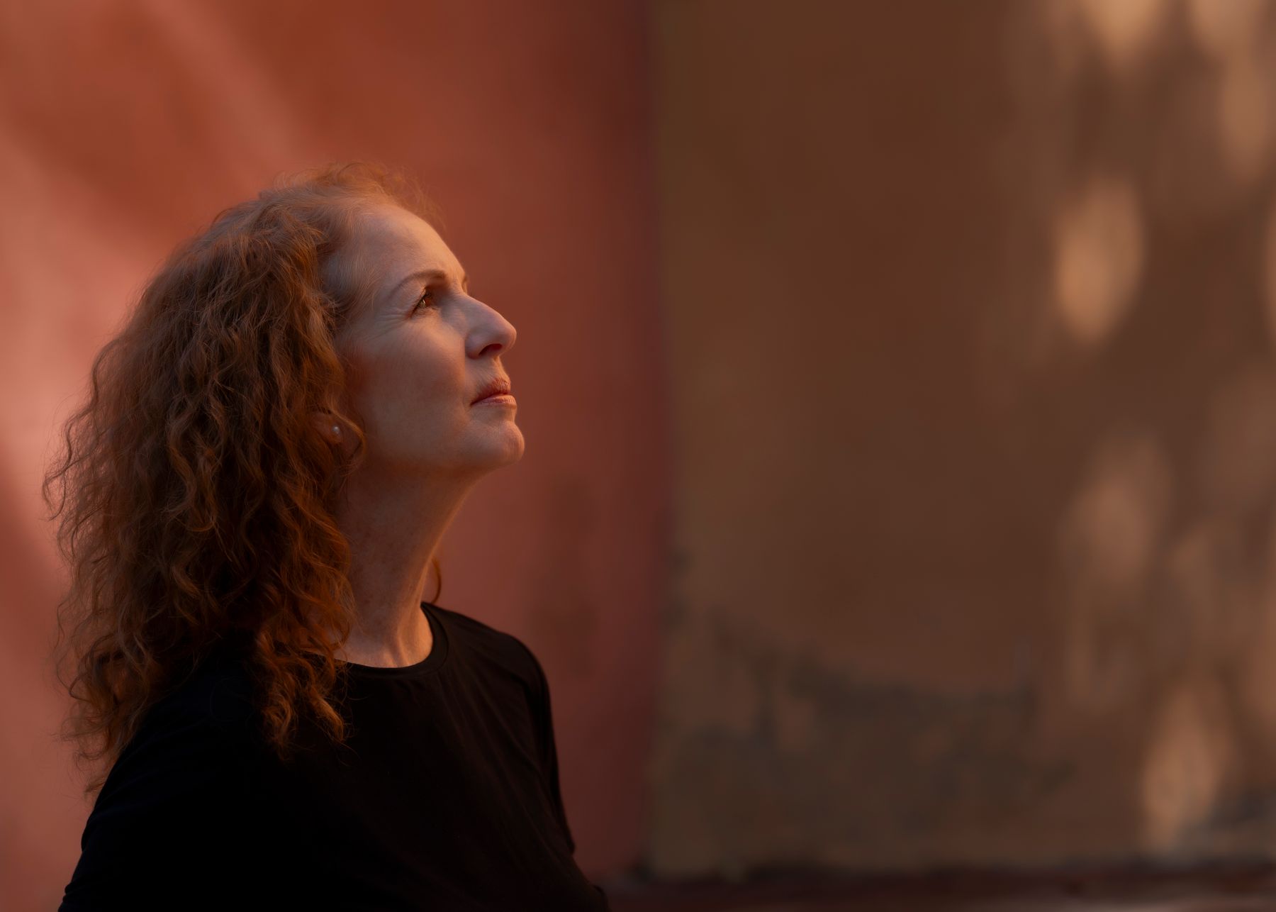 Elegant mature woman with long curly red hair