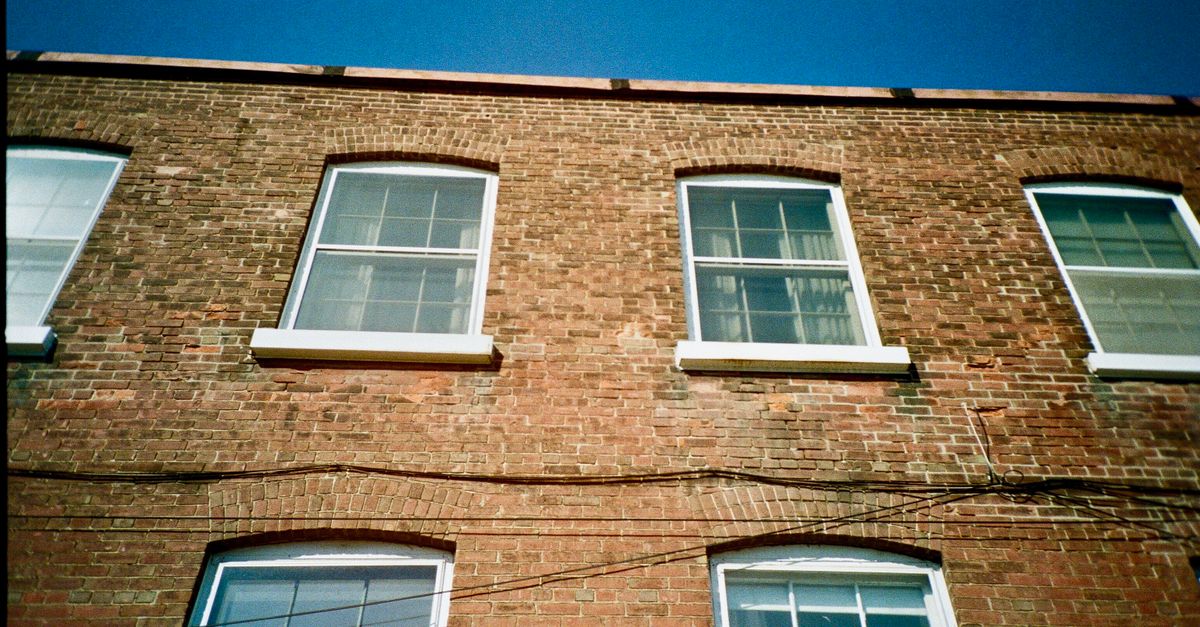 A low angle shot of a brick building facade with arched windows in Toronto, Canada.