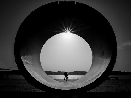 A man is standing in front of a large circular object