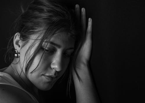 A woman is holding her head in her hands