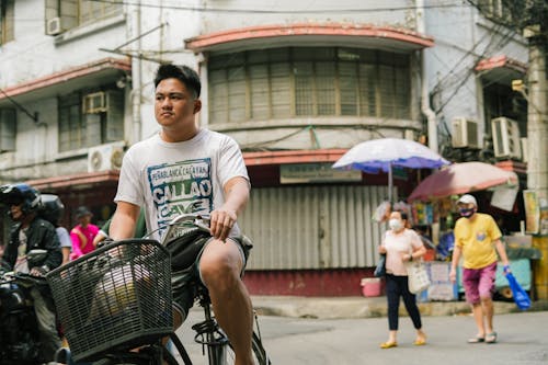 A man riding a bike in the middle of a busy street