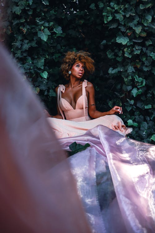 Free Woman Sitting in Dress among Leaves Stock Photo