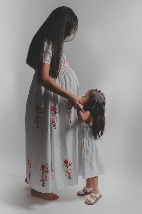 Daughter Kissing Pregnant Mother Abdomen