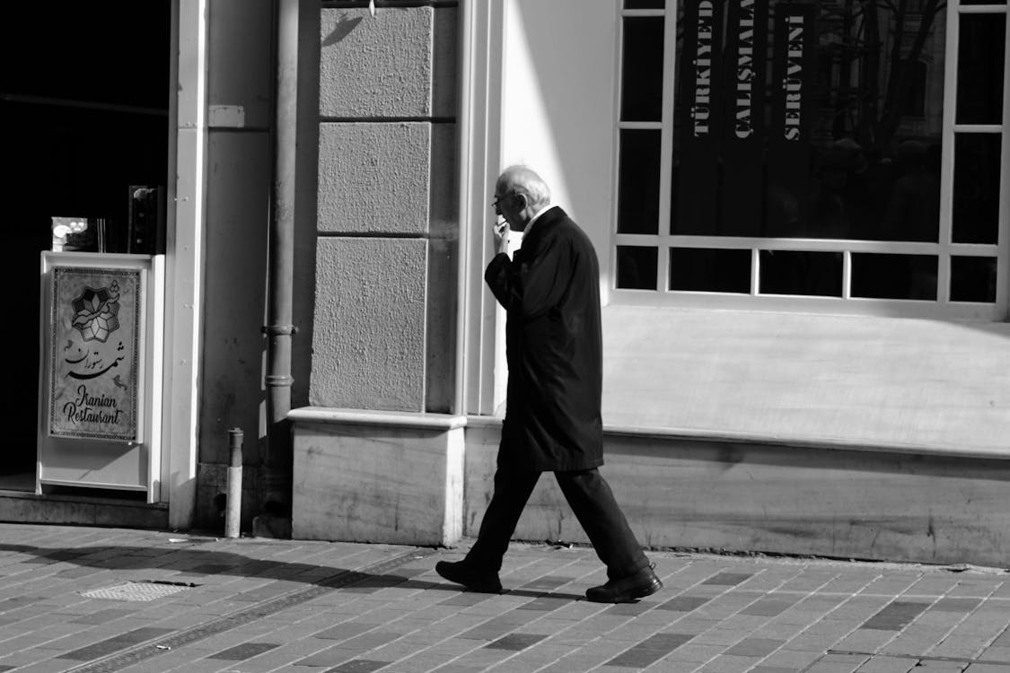 Elderly Man Walking and Smoking Cigarette