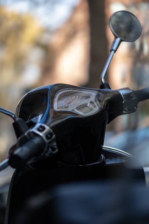 A close up of a motorcycle's handlebar and mirror