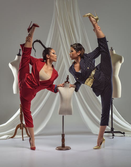 Two women in red suits doing a dance pose