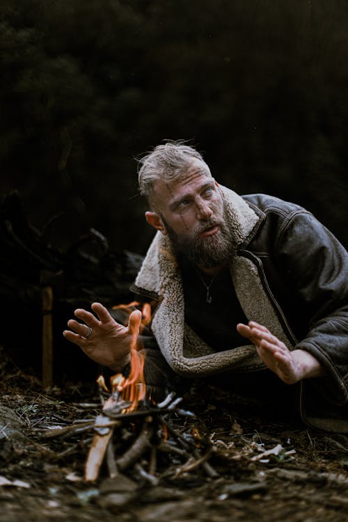 Man in Jacket Sitting by Bonfire