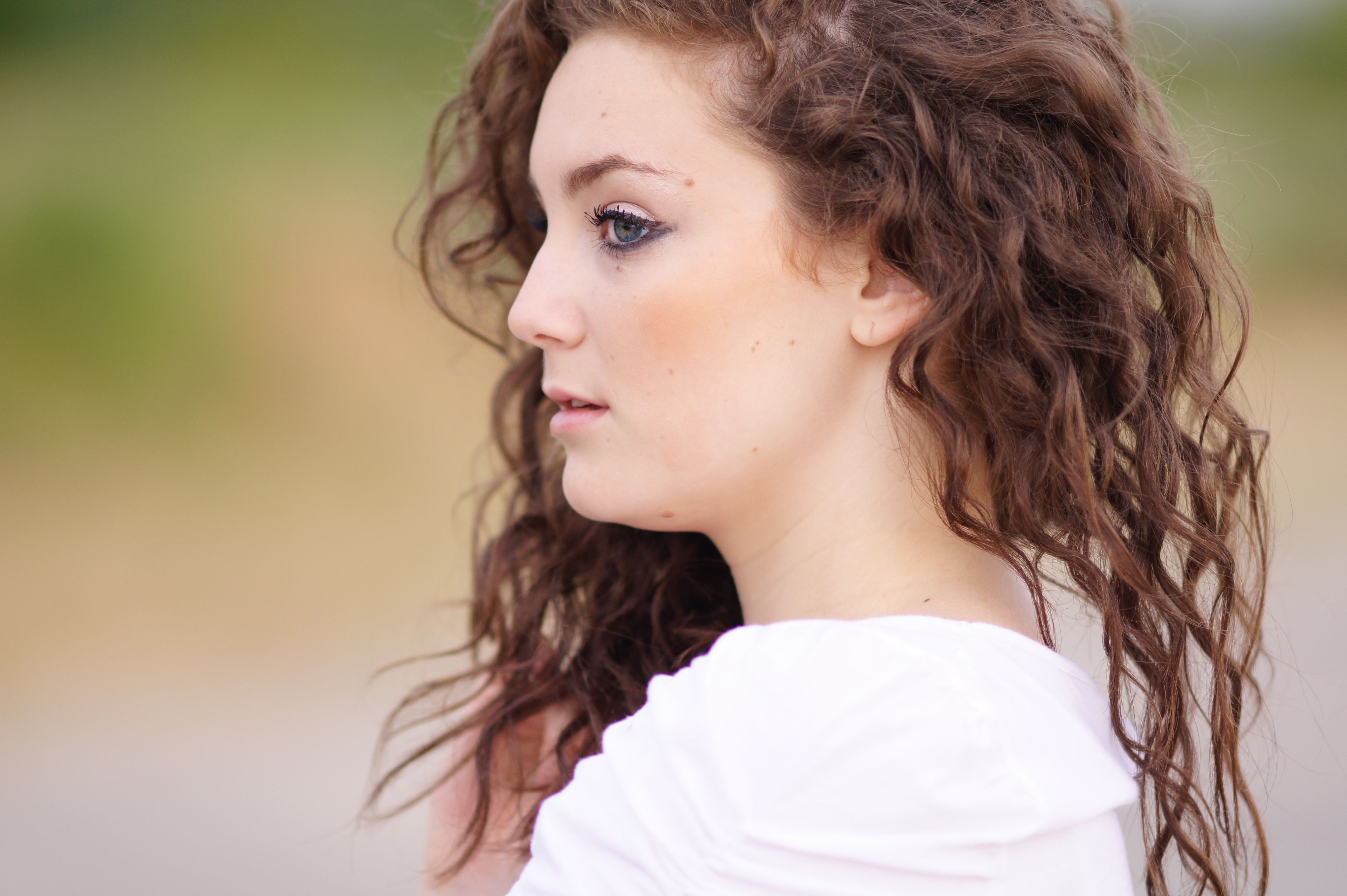 A woman with curly hair looking at the camera · Free Stock Photo