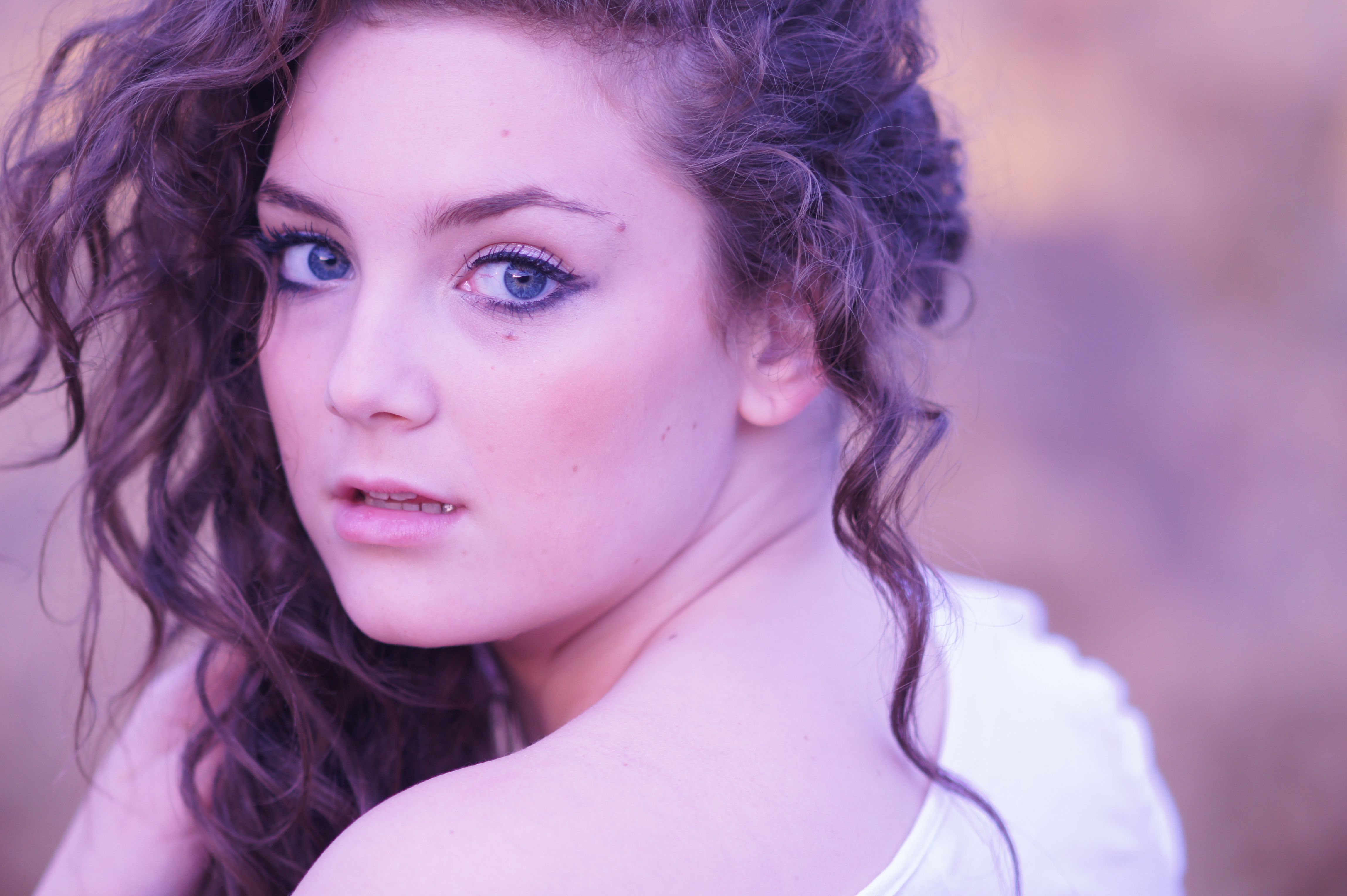 A beautiful young woman with long curly hair · Free Stock Photo