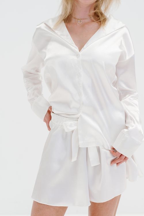 Free Stylish woman in elegant white sleepwear showcasing modern fashion indoors. Stock Photo