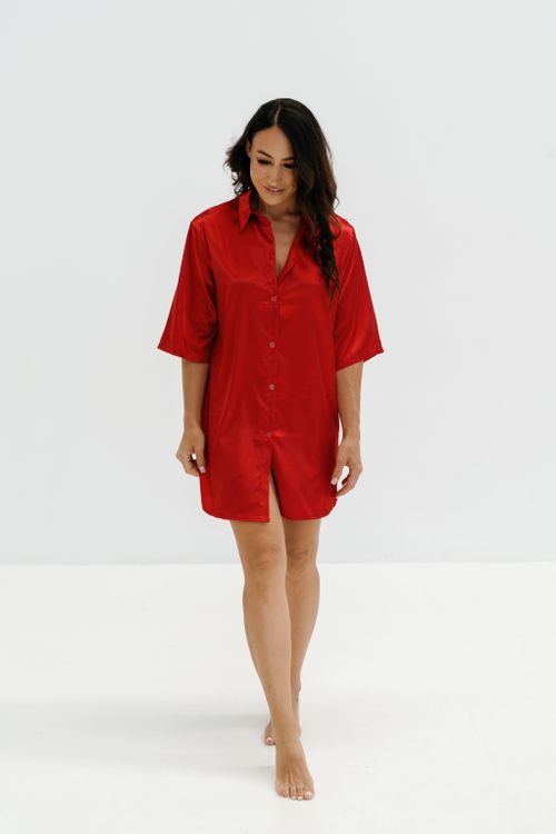 Free Portrait of a woman in a red nightshirt, exuding confidence and elegance, on a white backdrop. Stock Photo