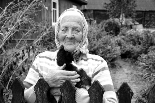 Elderly Woman Standing with Kitten