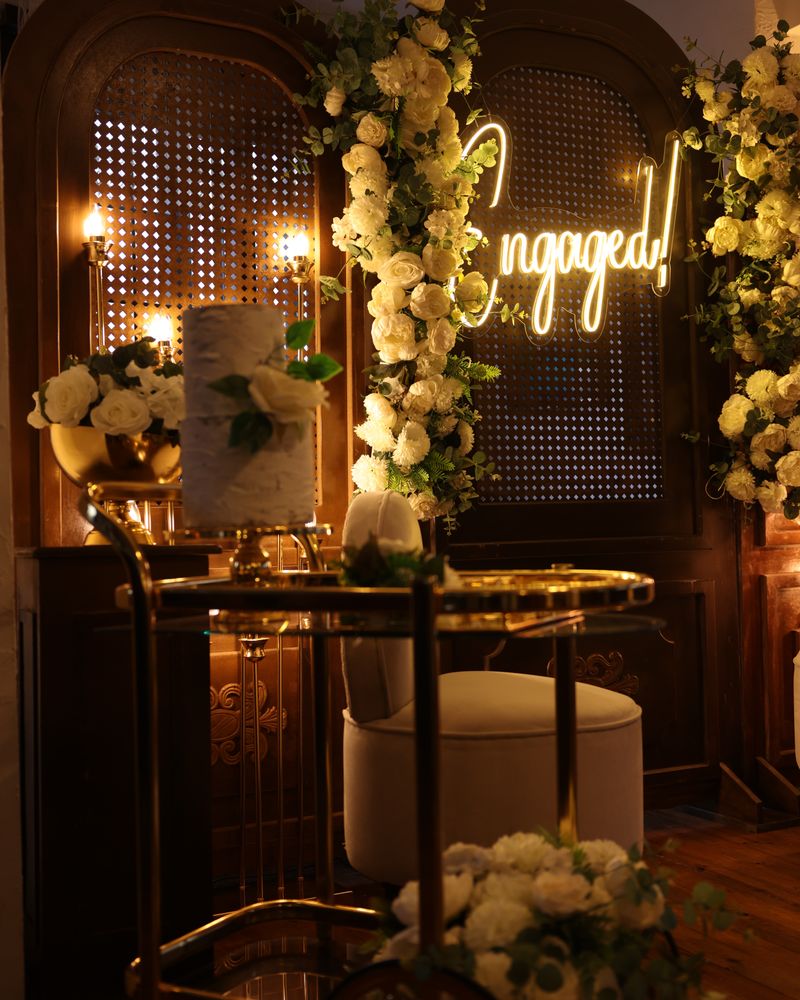 Engagement celebration space decorated with flowers and warm lighting