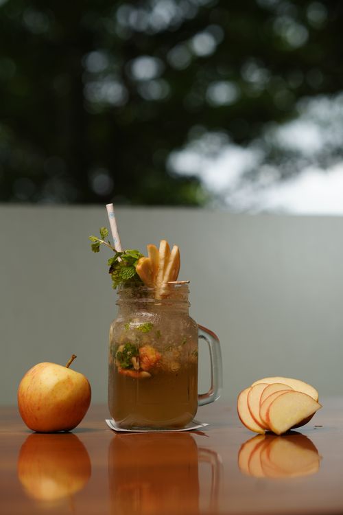 Free Close-up of a refreshing apple mint juice with fresh apple slices and mint leaves on a wooden table. Stock Photo