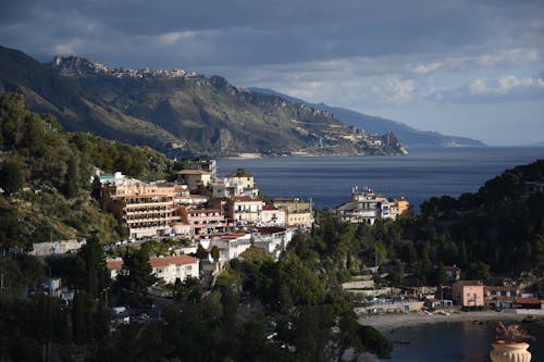 A view of a town on the coast with mountains in the background