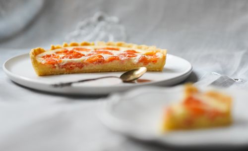 Free A delectable slice of grapefruit tart with a creamy topping on a white plate. Stock Photo