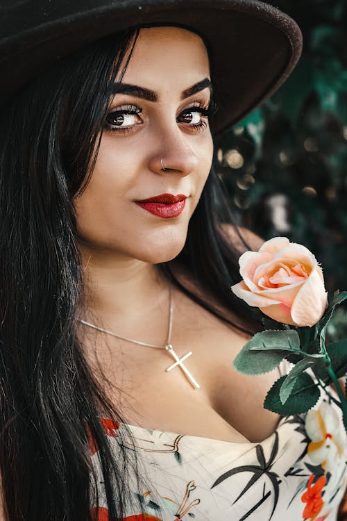 Close-up Photo of Woman in Floral Top Holding Pink Rose