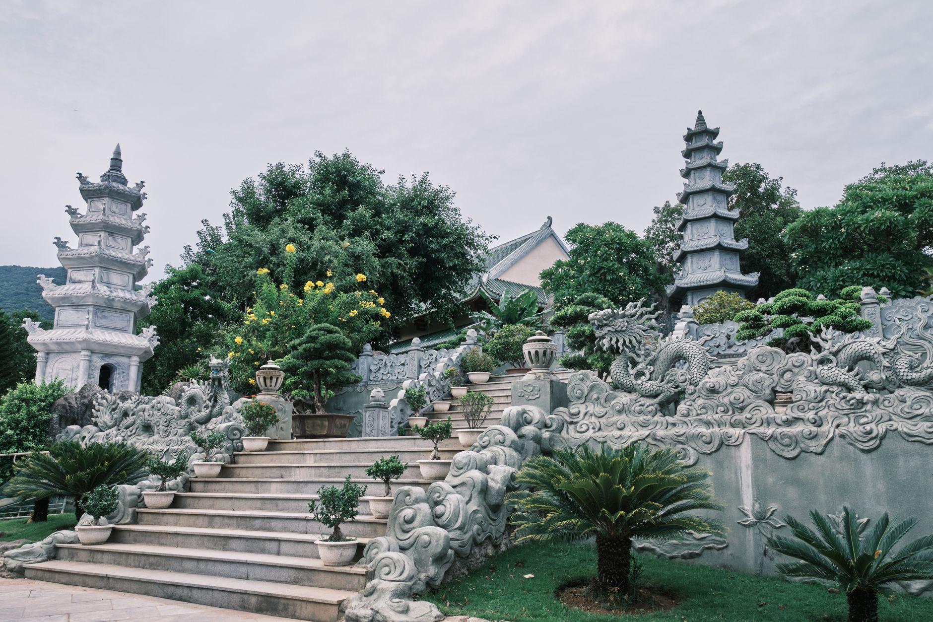 Beautiful Buddhist temple garden with pagodas in Đà Nẵng, showcasing lush greenery and intricate carvings.