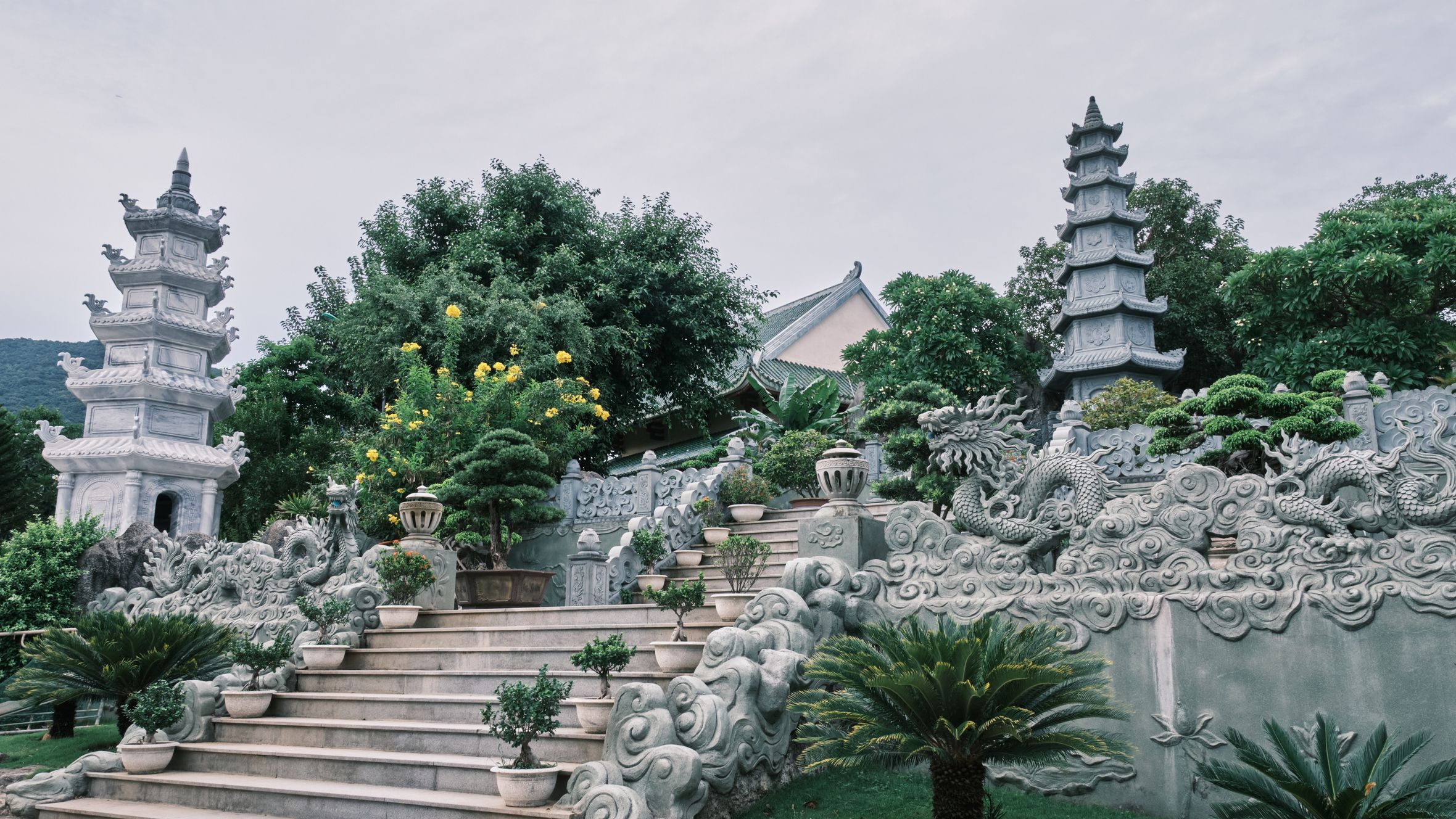 Beautiful Buddhist temple garden with pagodas in Đà Nẵng, showcasing lush greenery and intricate carvings.