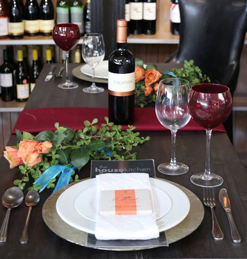 View of an Elegant Table Setting with Bottle of Wine Standing in the Middle 