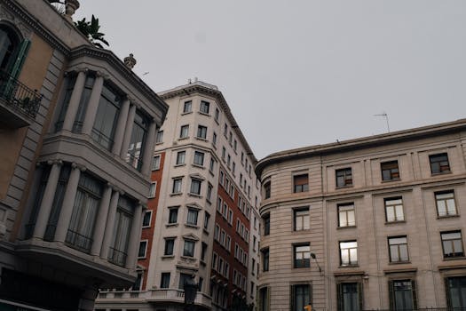Elegant architectural facades in Barcelona's urban landscape under a cloudy sky.