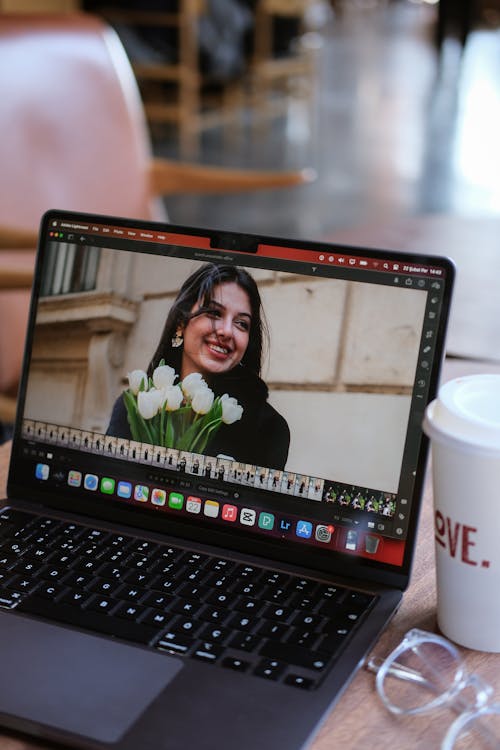 Photo of a Woman Holding Flowers Displayed on a Laptop Screen 