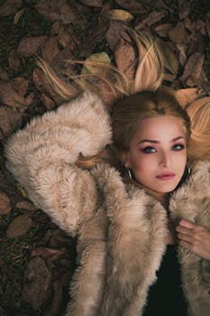 一位时尚女性躺在圣保罗的秋叶上，展现着时尚与美丽