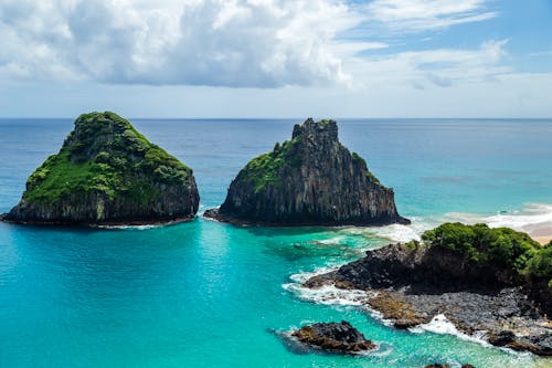 Two rocks in the ocean with blue water