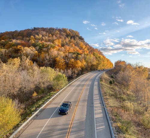 A car driving down a road in the fall