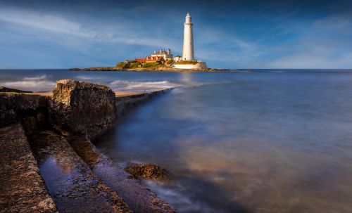 Free A scenic view of St Mary's Lighthouse with a long exposure, capturing the serene sea and rugged coastline. Stock Photo