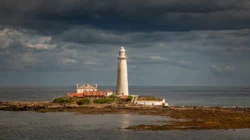 Free A picturesque view of St Mary's Lighthouse against a dramatic sky on the English coast. Stock Photo